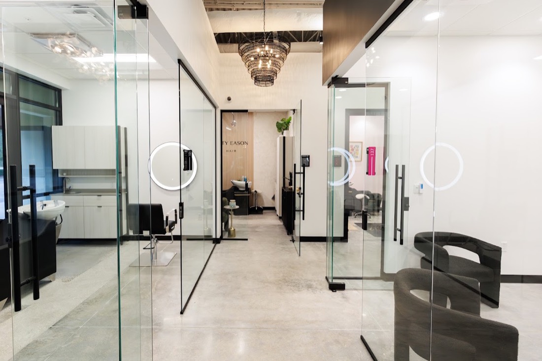 Corridor of glass-door salon suites installed by Interior Glass Solutions