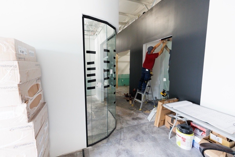Installer fitting a curved glass wall panel