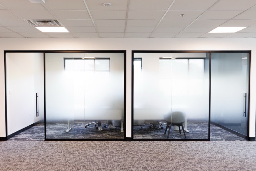 Frosted glass office suites with black framing — ATP Tour