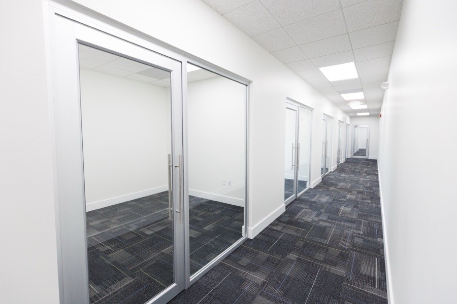 Aluminum-framed glass office doors along a hallway — Petticoat-Schmitt