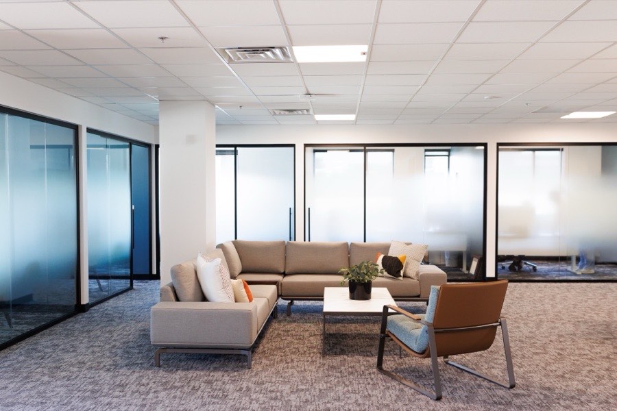 Open office lounge bordered by frosted glass offices — ATP Tour