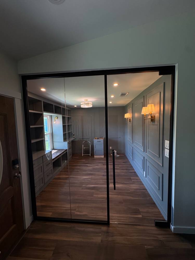 Full-height black-framed glass wall enclosing a home office with built-in shelving — Residential Office