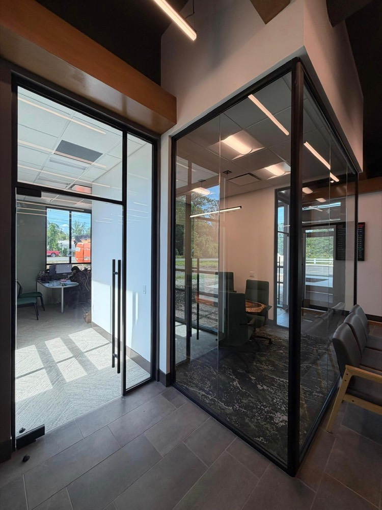 Black-framed glass conference room with a frameless glass door and matte-black hardware — Tru Fi Credit Union, Callahan FL